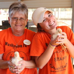 Staff members holding baby chickens