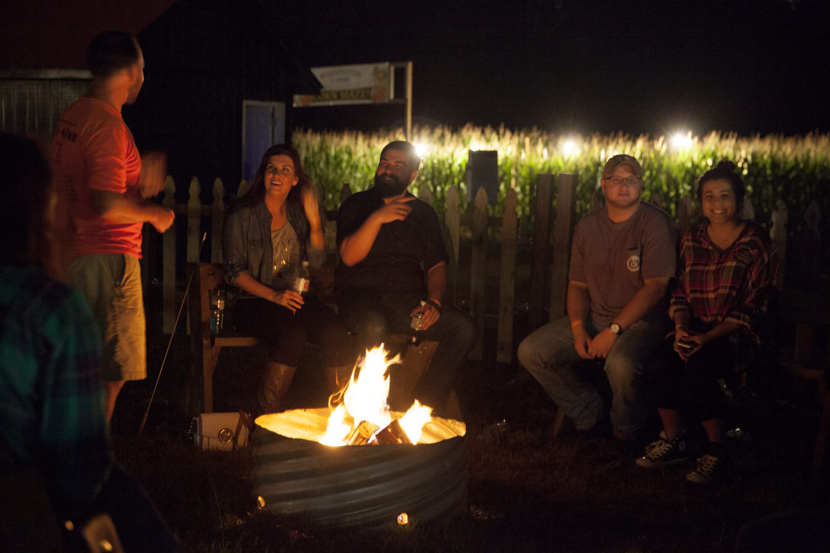 Friends talking around campfire
