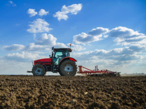 Farmer in tractor preparing land with seedbed cultivator