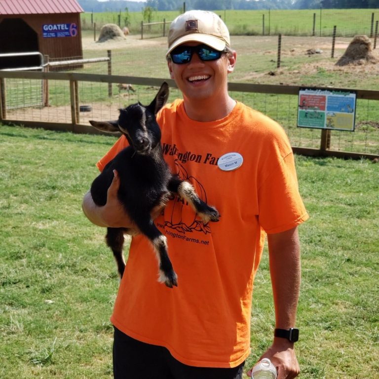Staff member holding a baby goat